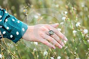 Young woman wearing beautiful silver ring with prehnite gemstone outdoors