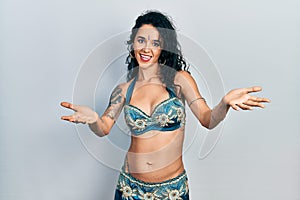 Young woman wearing bindi and traditional belly dance clothes smiling cheerful offering hands giving assistance and acceptance