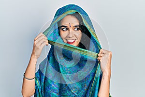 Young woman wearing bindi wearing traditional indian saree happy face smiling with crossed arms looking at the camera