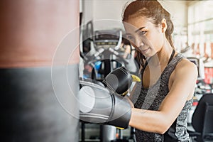 Young woman wearing boxing glove in gym