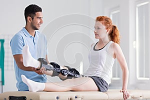 Young woman wearing a brace during rehabilitation with her physiotherapist photo