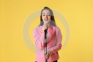 Young woman wearing casual clothes singing in microphone