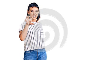 Young woman wearing casual clothes smiling funny doing claw gesture as cat, aggressive and sexy expression