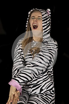 Young woman wearing cat pajamas in a deep yawn