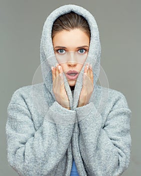 Young woman wearing coat hood sirprising.