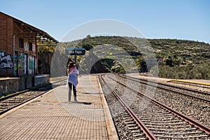 A young woman wearing a cowboy hat takes a photograph of the Extremadura railway track near Garrovillas de Alconetar