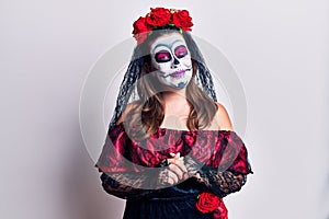 Young woman wearing day of the dead costume over white with hands together and crossed fingers smiling relaxed and cheerful