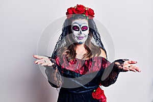 Young woman wearing day of the dead costume over white smiling cheerful with open arms as friendly welcome, positive and confident