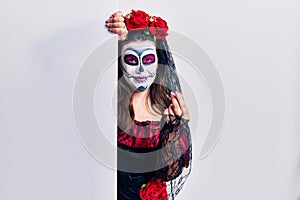 Young woman wearing day of the dead custome holding blank empty banner doing money gesture with hands, asking for salary payment,