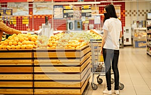 Young woman wearing disposable medical mask shopping in supermarket during coronavirus pneumonia outbreak.