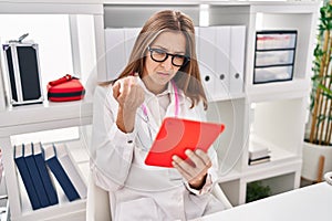 Young woman wearing doctor uniform having teleconsultation at clinic