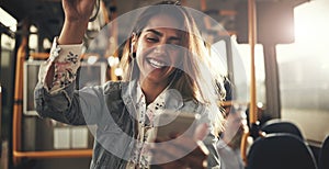 Smiling young woman standing on a bus listening to music