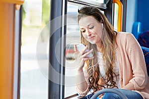 Young Woman Wearing Earphones Listening To Music On Bus