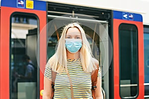 Young woman wearing face mask and backpack