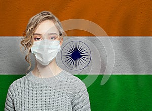 Young woman wearing a face mask with national indian flag. Flu epidemic and virus protection concept