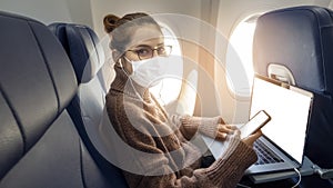 A young woman wearing face mask is traveling on airplane , New normal travel after covid-19 pandemic concept