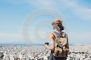 Young woman wearing hat looking at a big city. Traveler girl enjoying vacation. Summer holidays, vacation, travel, tourism concept