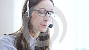 Young woman wearing headphones, communicating online via laptop, explaining, teaching. Distance education, businesswoman