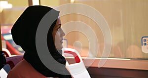 Young woman wearing hijab commuting on a bus