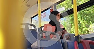 Young woman wearing hijab commuting on a bus
