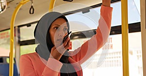 Young woman wearing hijab commuting on a bus