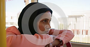 Young woman wearing hijab commuting on a bus