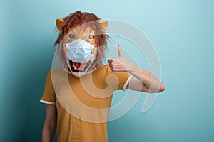 Young woman wearing lion and protection medical mask show thumbs up approval gesture
