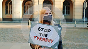 Young woman wearing medical mask calling to stop the tyranny by holding steamer