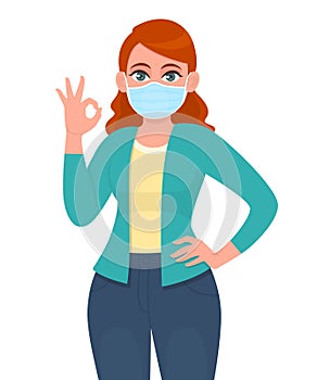Young woman wearing medical mask and showing okay, OK sign. Trendy girl covering face protection from epidemic and gesturing.