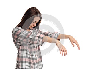 Young woman wearing pajamas in sleepwalking state on white background