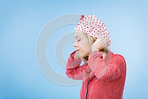 Young woman wearing pink pajamas putting bathing cap