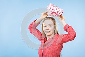 Young woman wearing pink pajamas putting bathing cap