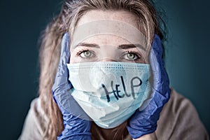 Young woman wearing protective gloves and face mask inside a home in quarantine looking bored and sad, for Covid-19 Coronavirus,