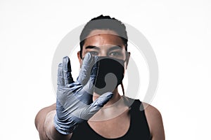 Young woman wearing protective mask on face and medical gloves. Showing vulcanian sign. Confident girl, female doctor in medical