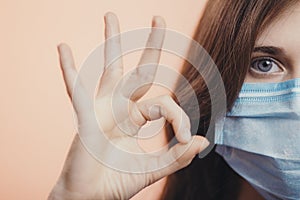 Young woman wearing a protective mask on face and showing gesture ok, concept health, survivor behavior, obedience quarantine