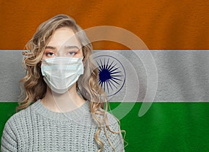 Young woman wearing a protective mask with national indian flag. Flu epidemic and virus protection concept