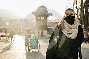Young woman wearing a protective mask with a valve. Living in the polluted city. Coronavirus COVID-19 pandemic mandatory masks on