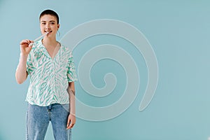 Young woman wearing shirt smiling and eating candy gummy