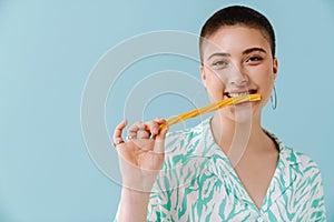 Young woman wearing shirt smiling and eating candy gummy