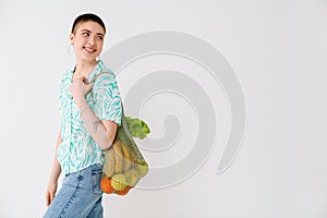 Young woman wearing shirt smiling while posing with bag
