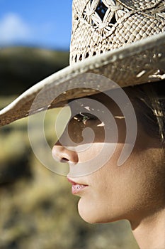 Young woman wearing a straw cowboy hat.