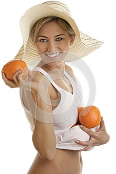 Young woman wearing straw hat with fresh juicy oranges