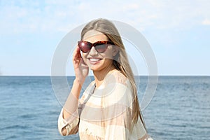 Young woman wearing sunglasses near river