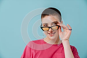 Young woman wearing sunglasses smiling and looking at camera