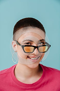 Young woman wearing sunglasses smiling and looking at camera