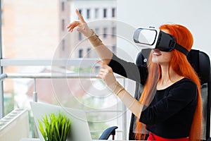 Young woman wearing virtual reality goggles in modern coworking studio.