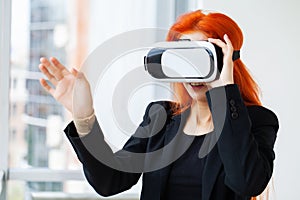 Young woman wearing virtual reality goggles in modern coworking studio.