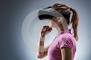 Young woman wearing virtual reality headset in studio. Emotions. Side view