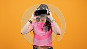 Young woman wearing VR goggles on heand and enjoys virtual reality