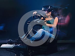 Young woman wearing VR headset having fun while driving on car racing simulator cockpit with seat and wheel.